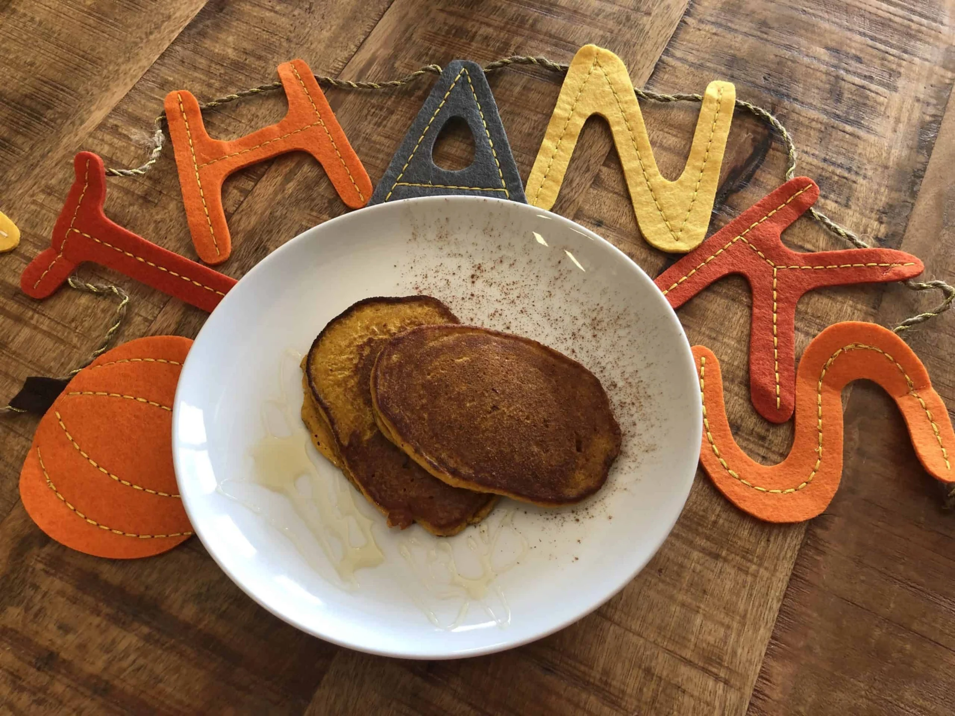A plate of pumpkin pancakes with thanks written on it.