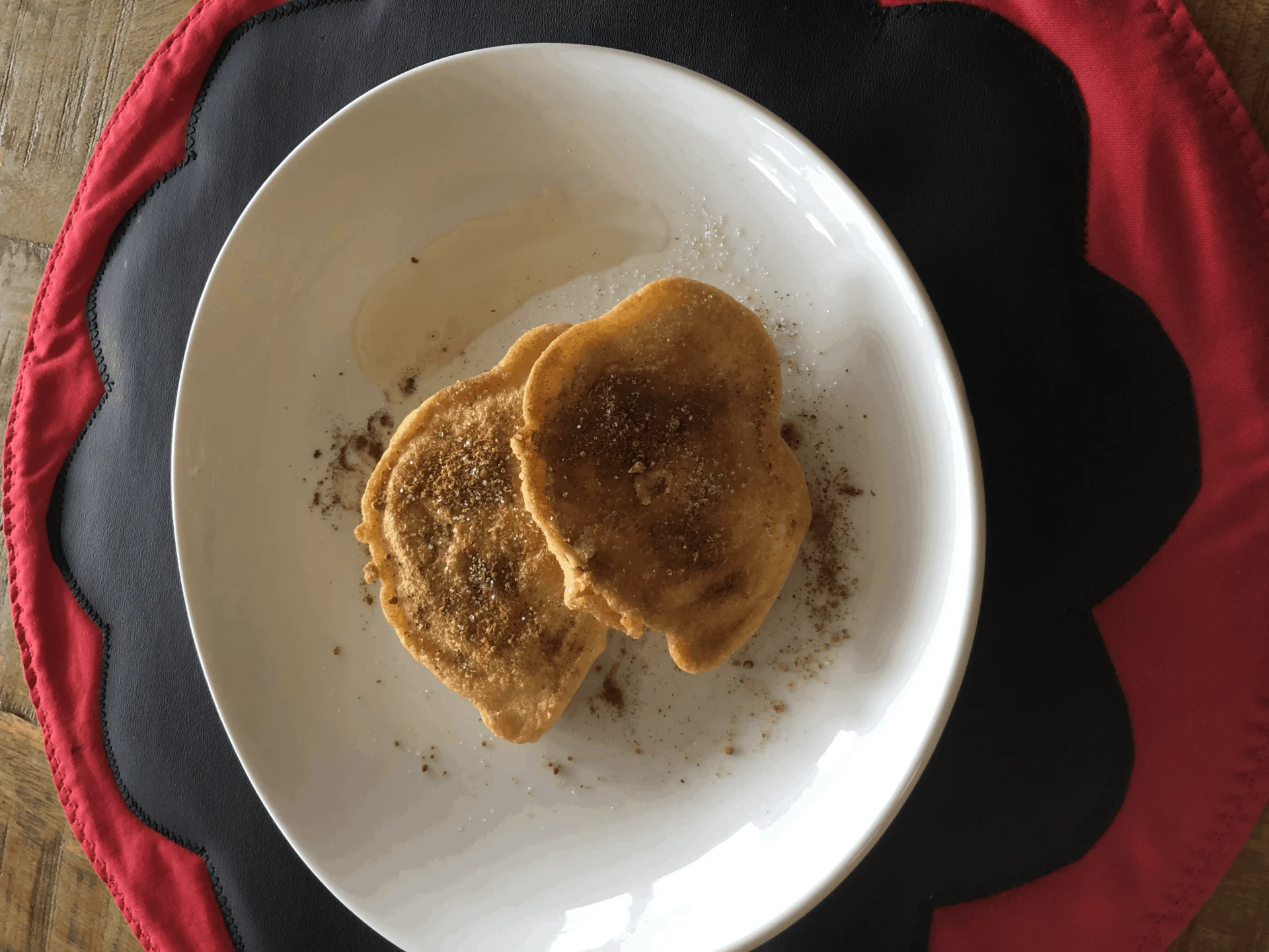 Fried apple ring pancakes on a plate on a table.