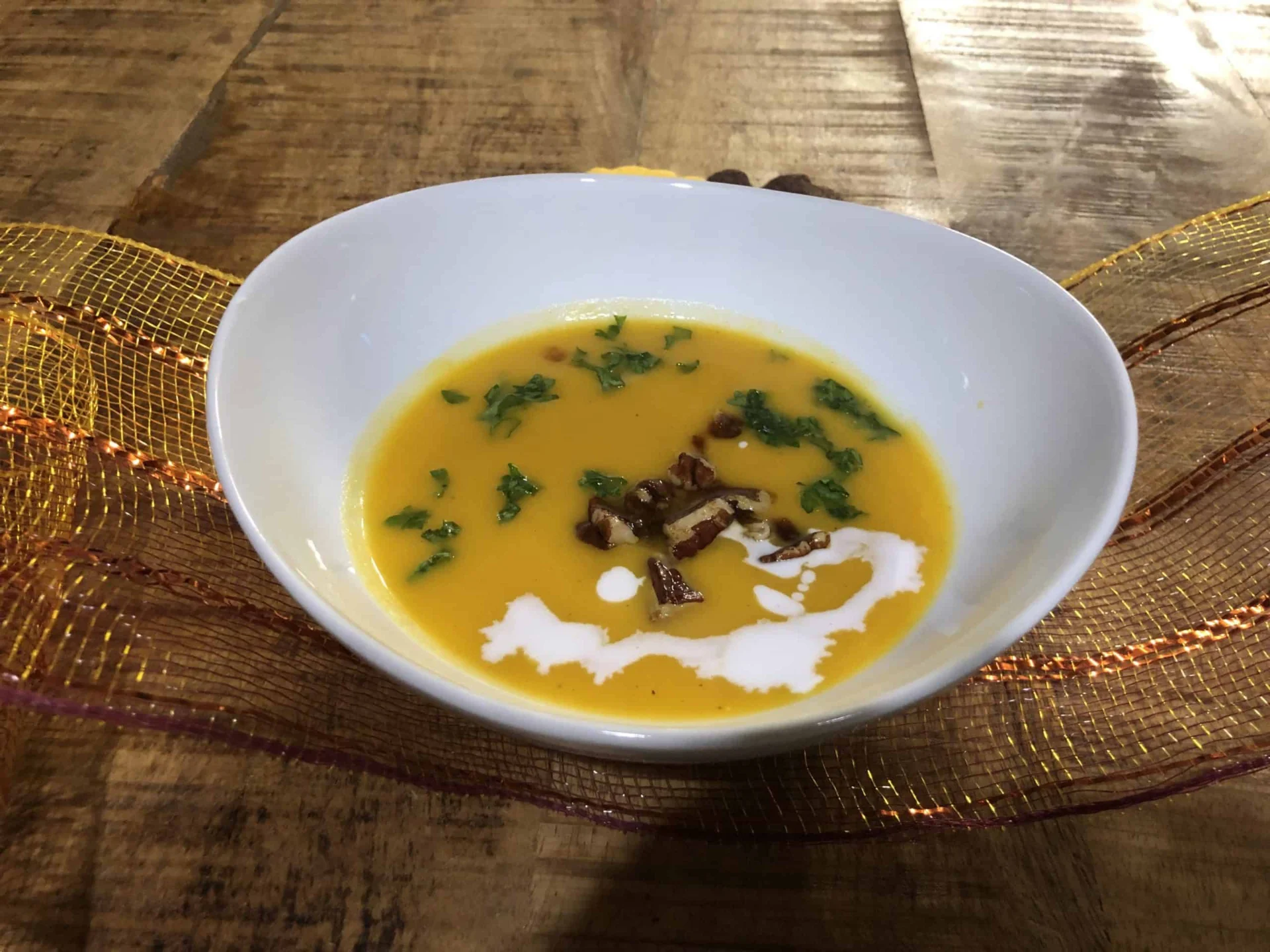 A bowl of soup with nuts and sour cream.