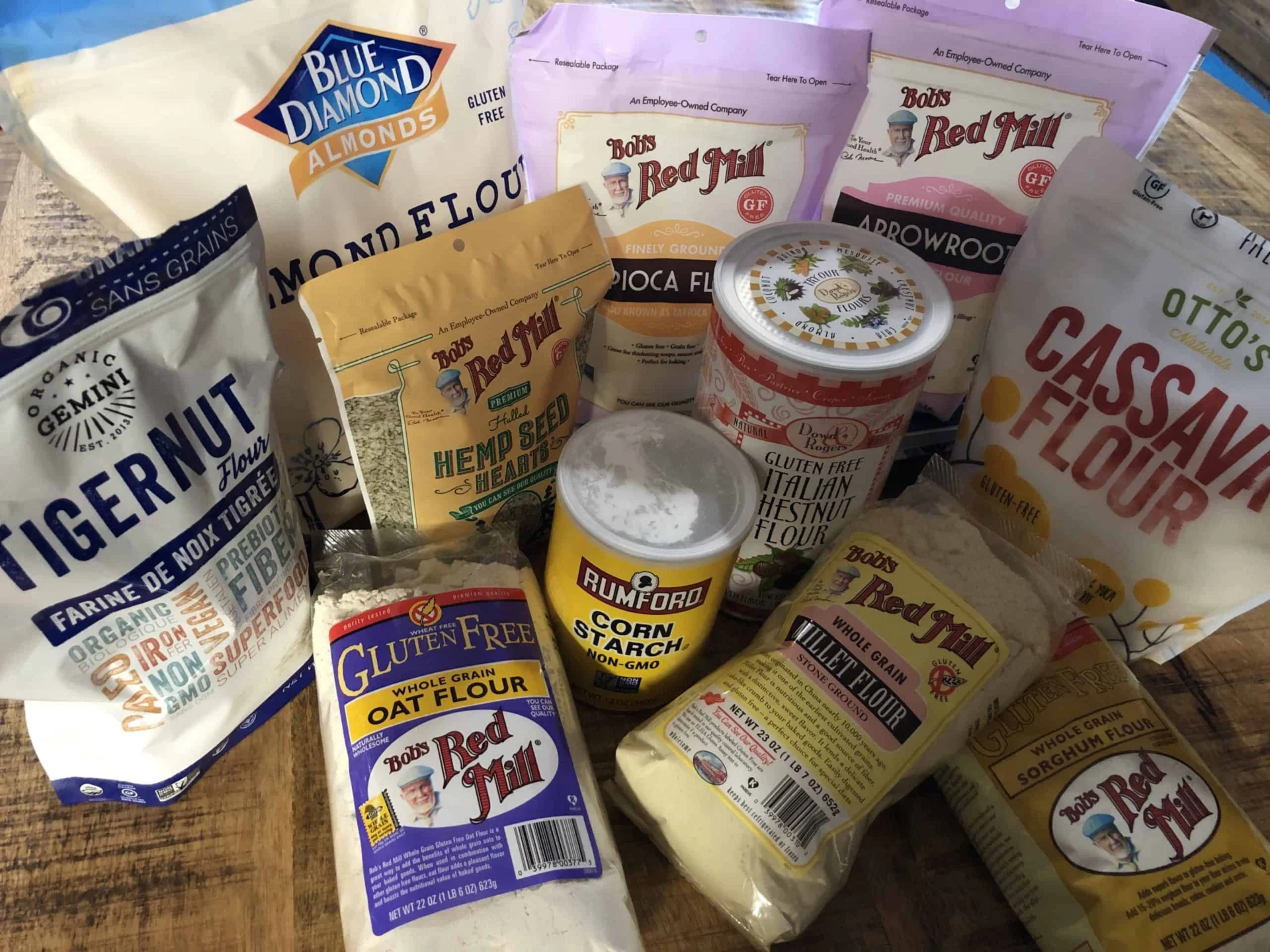 A variety of flours and other ingredients on a table.
